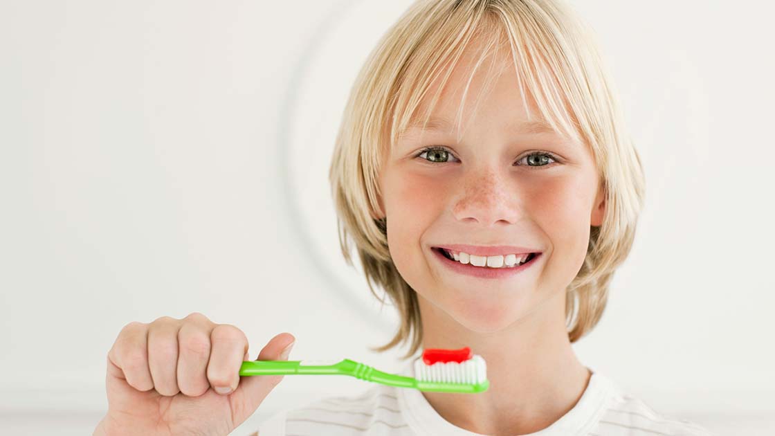 Blonde boy brushing teeth